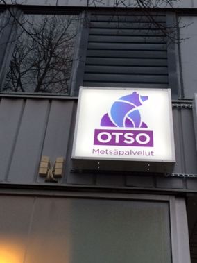 Otso Metsäpalveluiden logo valomainoksena rakennuksen seinässä.
