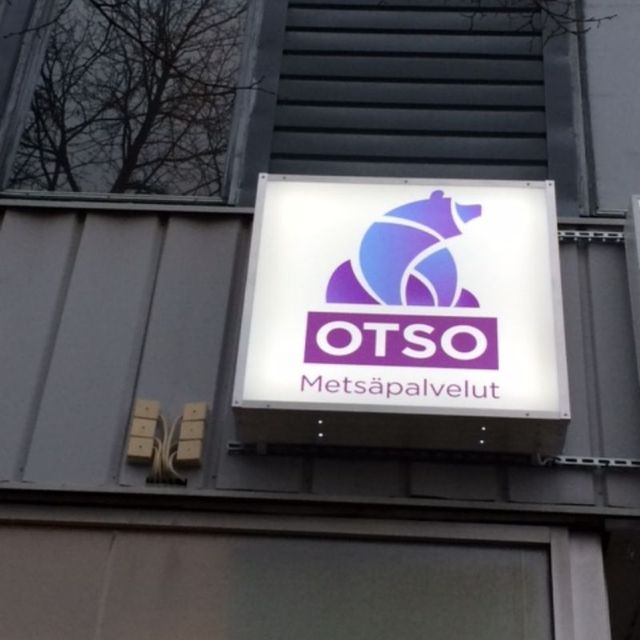Otso Metsäpalveluiden logo valomainoksena rakennuksen seinässä.