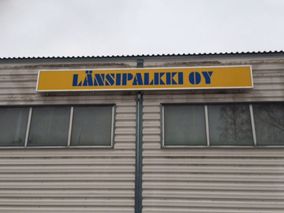 Keltainen Länsipalkki Oy -valomainos katonrajassa.